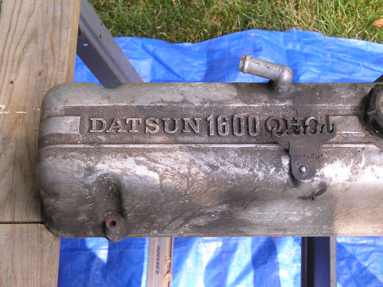 Close up of early L series valve cover with "DATSUN 1600 OHC" Ins